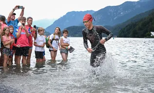 Triatleta che esce dal lago tra il pubblico