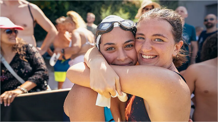 Two swimmers hugging after the race